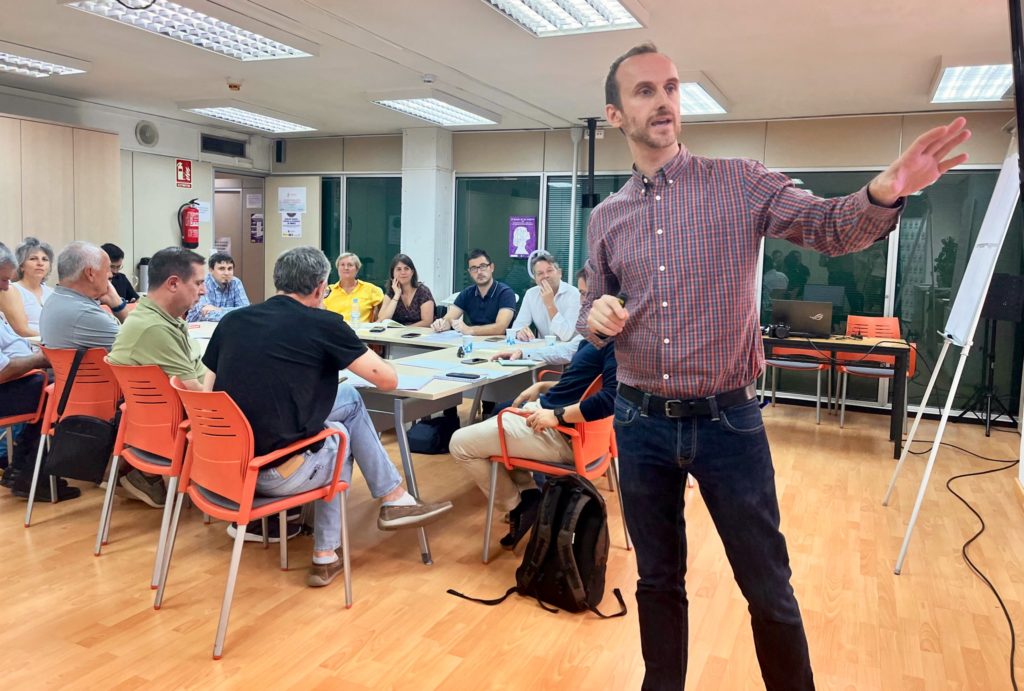 Person giving a talk in front of a group of people.